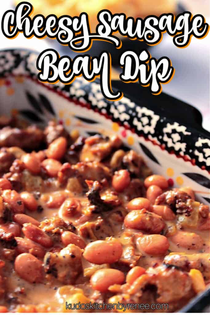 A vertical closeup photo along with a title text graphic of Cheesy Sausage Bean Dip in a square casserole dish.