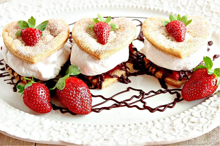 Three Deconstructed Strawberry Pies on a pretty platter with chocolate ganache and fresh strawberries as garnish.