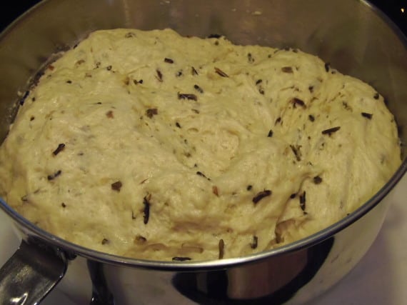 Fully proofed wild rice bread dough in the bowl of a stand mixer.