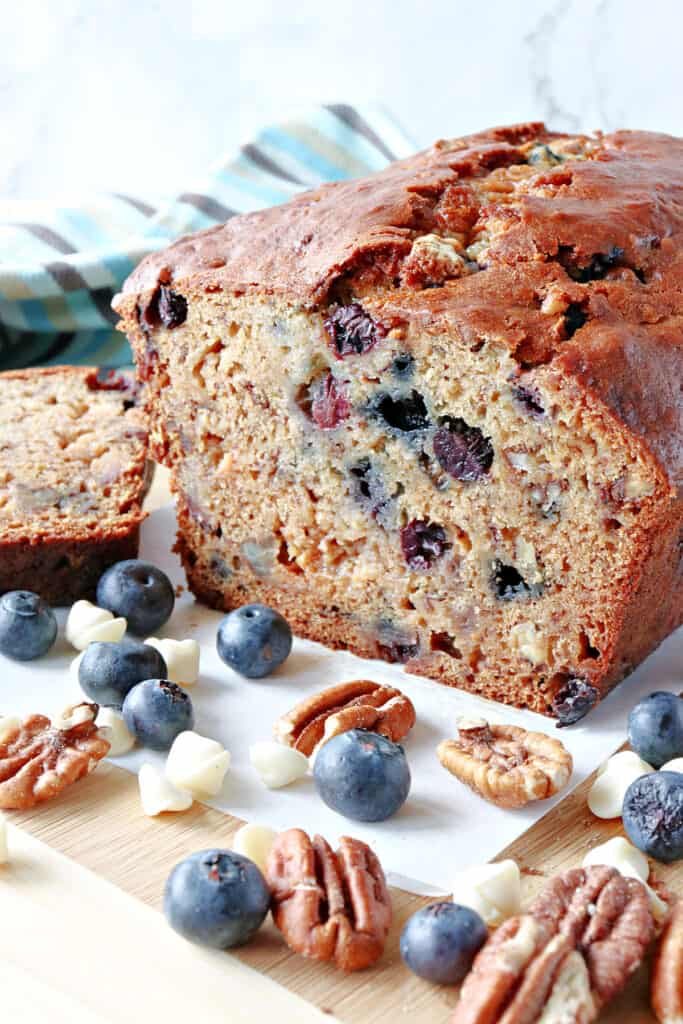 A vertical closeup of the inside of a Blueberry Banana Quick Bread which shows pecans, and blueberries inside.