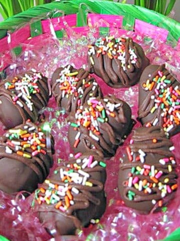 Chocolate Peanut Butter Eggs in a basket with pink Easter grass.