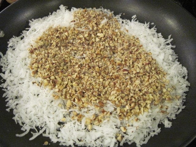 Coconut and chopped pecans in a skillet.