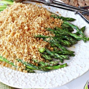 A pretty white platter filled with Grandma's Asparagus with Breadcrumbs.