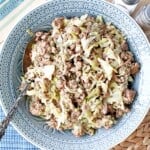 Ground Pork and Cabbage Skillet in a blue bowl with a serving spoon.