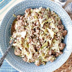 Ground Pork and Cabbage Skillet in a blue bowl with a serving spoon.
