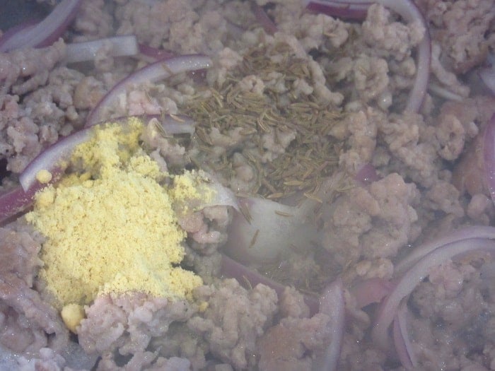 Browned ground pork and onions in a skillet along with garlic.