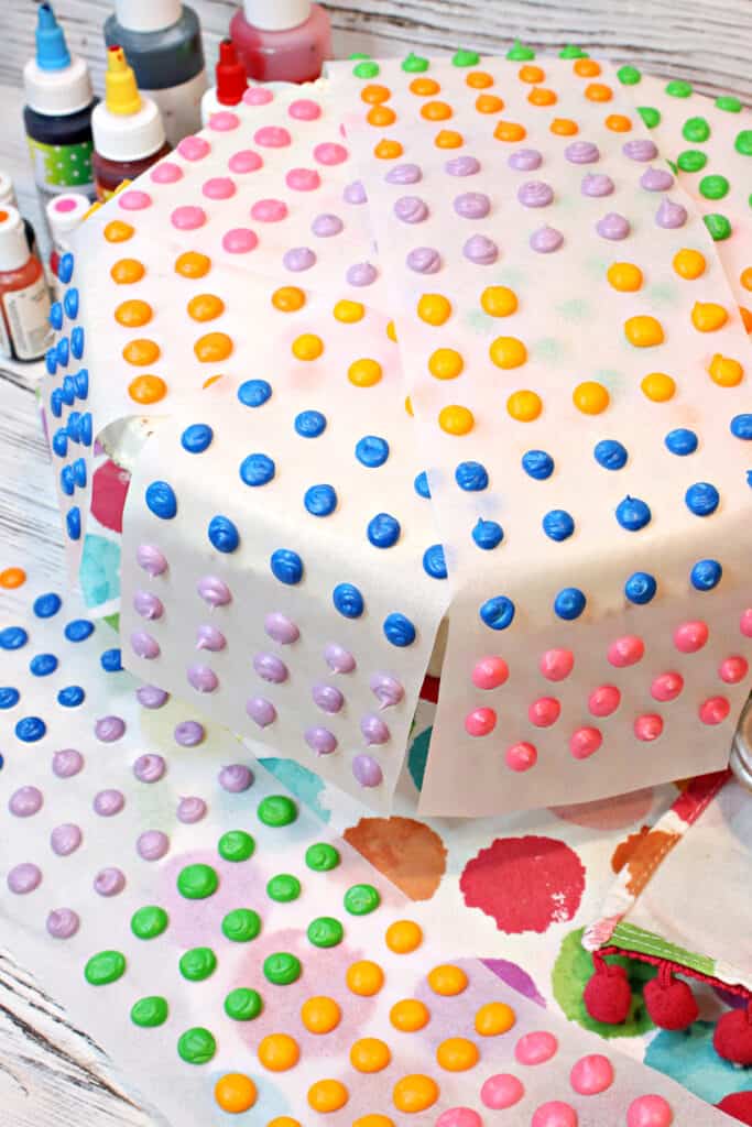 A vertical closeup of many strips of colorful Homemade Candy Dots with pink, green, purple, and yellow candy.