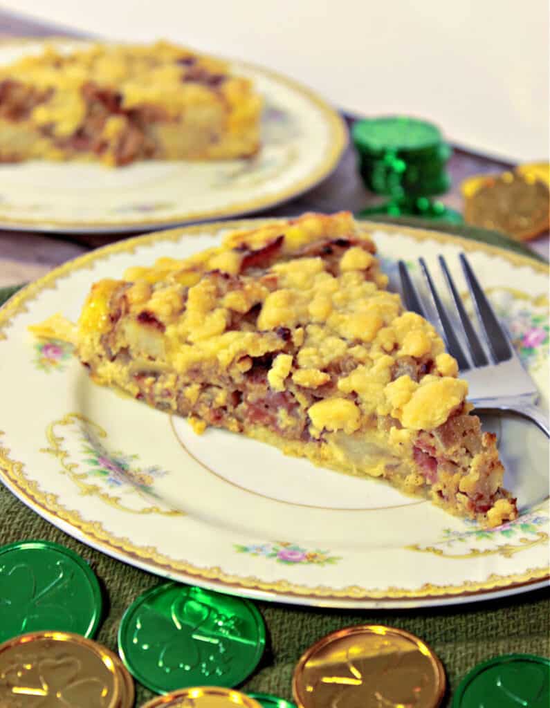 A vertical closeup of a slice of Irish Cheese and Potato Tart on a pretty plate with gold and green coins in the front.
