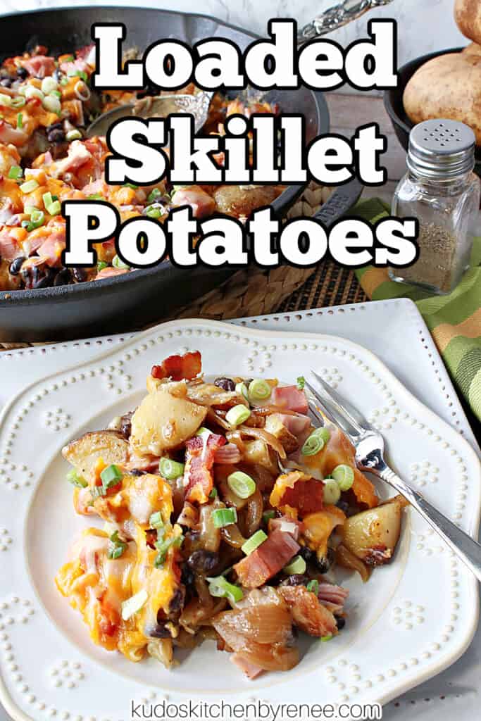 A vertical closeup along with a title text overlay graphic for Loaded Skillet Potatoes on a white plate along with a cast iron skillet in the background.