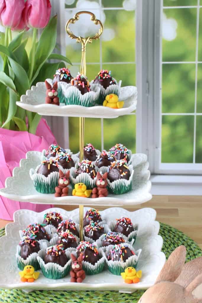 A pretty three tiered stand filled with Chocolate Peanut Butter Eggs with Coconut and Pecans.