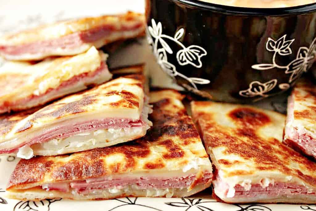 A super closeup of wedges of Reuben Quesadillas with corned beef, Swiss cheese, sauerkraut and flour tortillas.