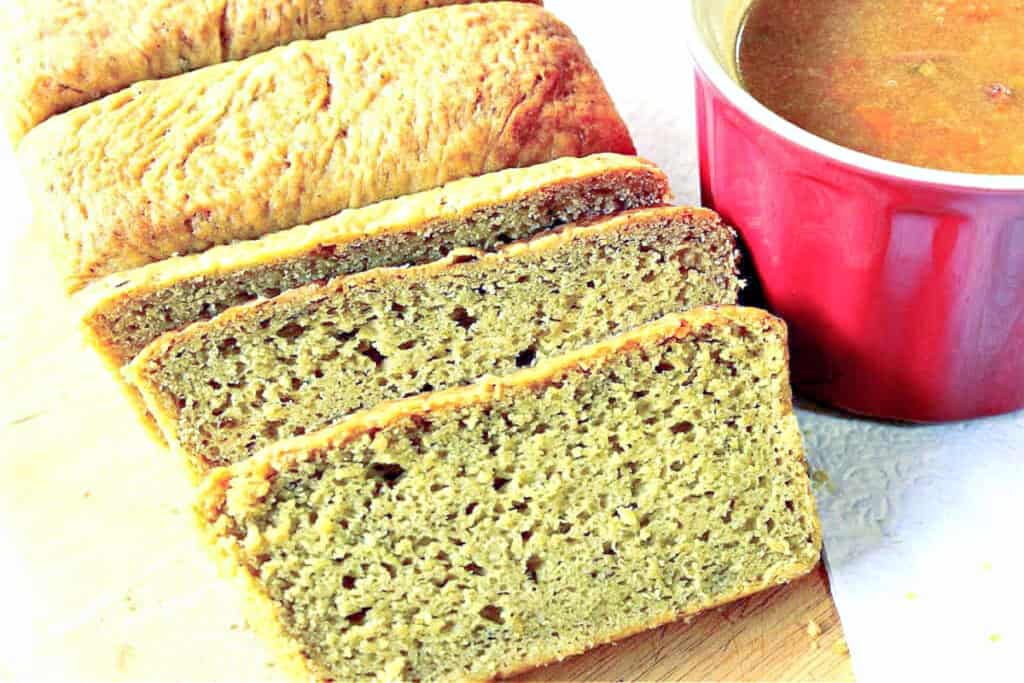 A horizontal photo of a sliced loaf of Avocado Yeast Bread with a mug of soup on the side.