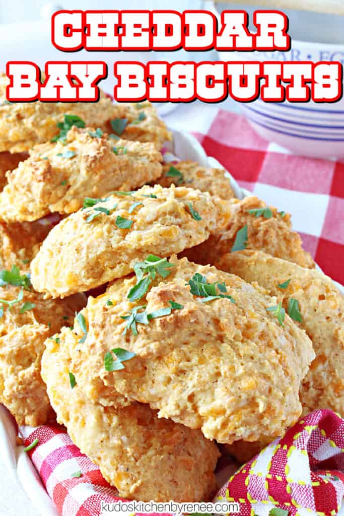 A closeup image of a cheesy Cheddar Bay Biscuits along with chopped parsley and also a title text overlay image.