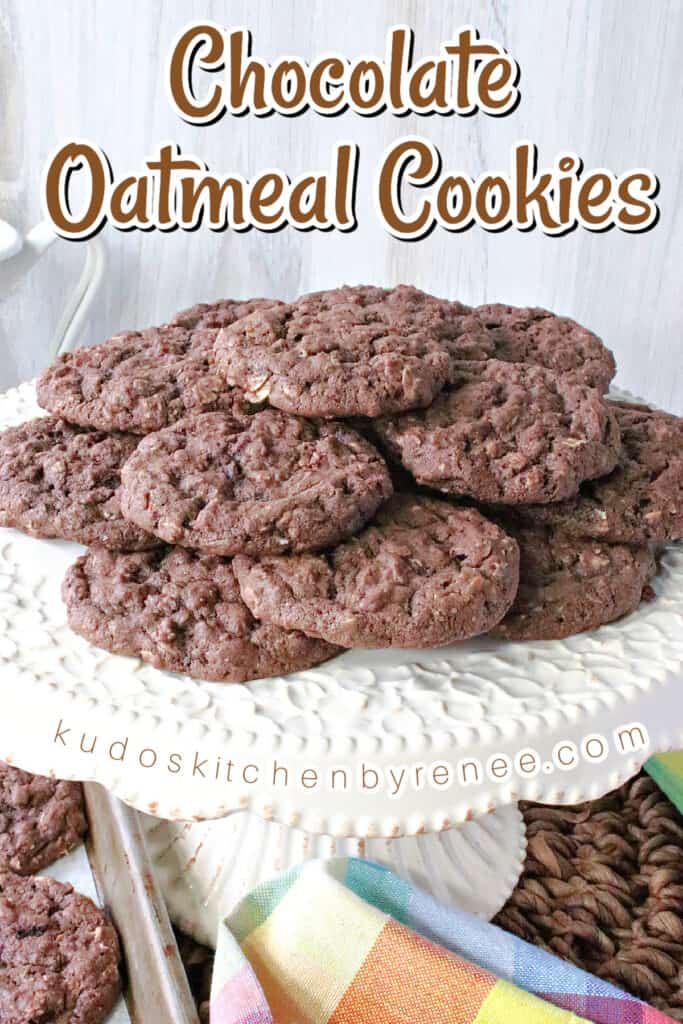 A vertical closeup along with a title text overlay graphic for Chocolate Oatmeal Cookies on a white cake stand.
