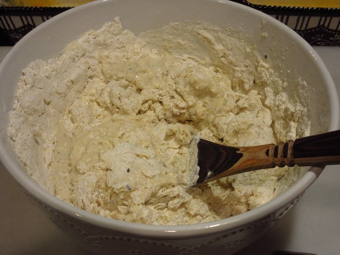 A wooden spoon mixing flour and milk.