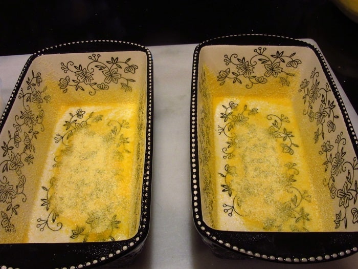 Two loaf pans sprinkled with cornmeal.