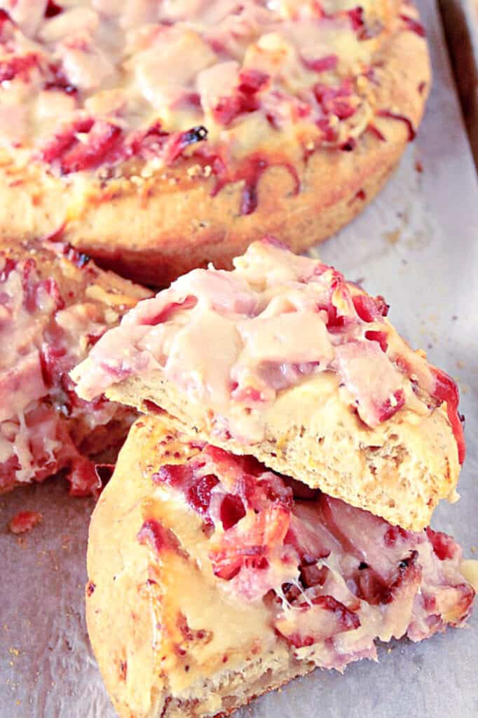 A vertical closeup image of a sliced Leek and Onion Focaccia with ham and cheese.