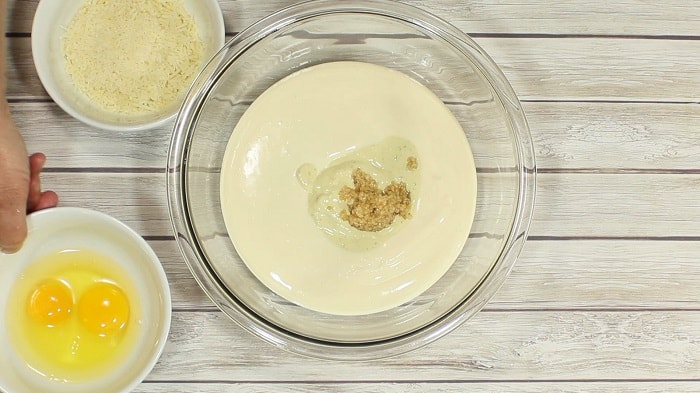 Garlic in a bowl with Alfredo sauce.