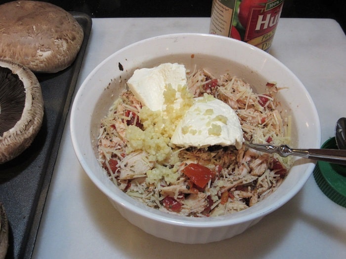 Ricotta cheese in a bowl with the ingredients for Chicken Parmesan Stuffed Portobellos.