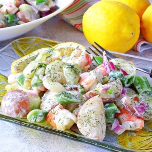 A colorful serving of cucumber shrimp salad on a glass plate.