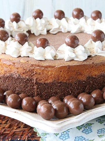 A luscious looking Malted Milk Ball Cheesecake with whipped cream and malted milk balls as garnish.