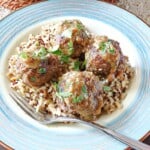 Four Pork Meatballs with Apples and Onion on a plate with rice.