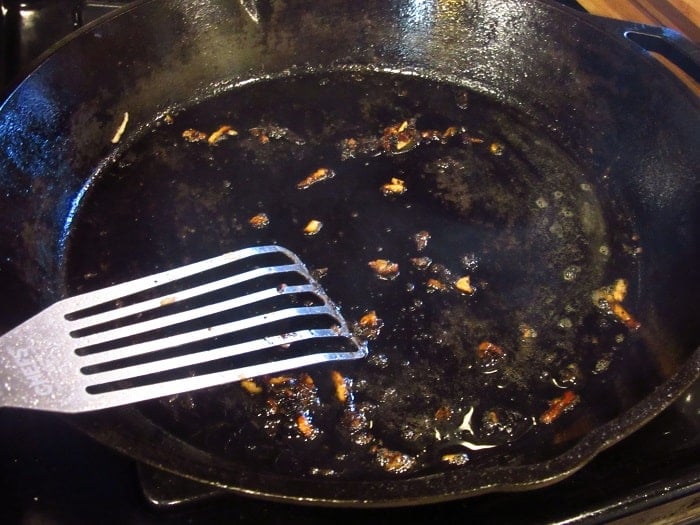 A slotted spatula in a cast iron skillet.