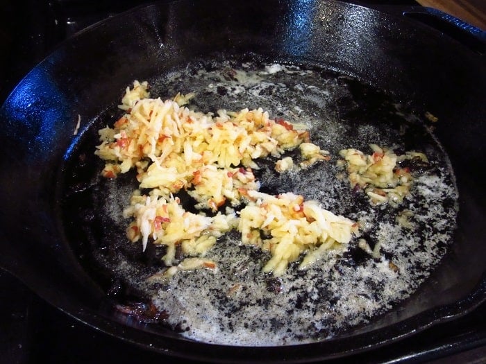 Grated apple in a cast iron skillet.