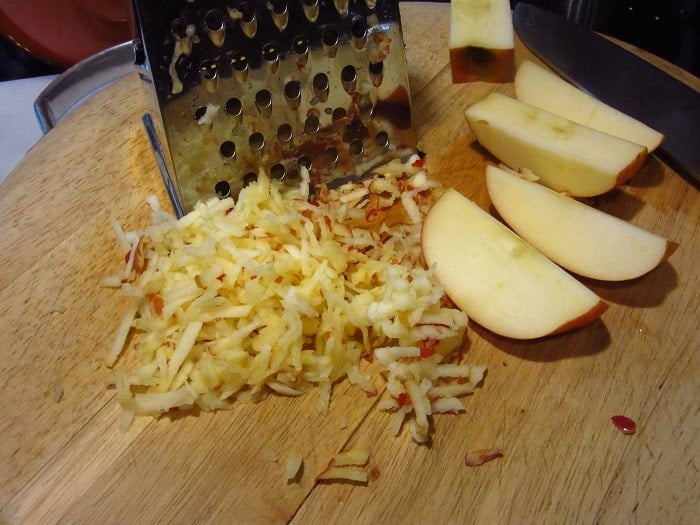 Grated apples on a cutting board.