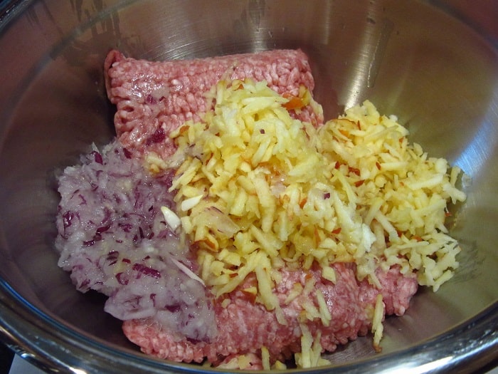 Ground Pork grated apple and onion in a bowl.