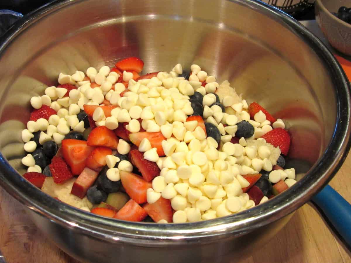 White chocolate chips in a bowl with fresh berries.