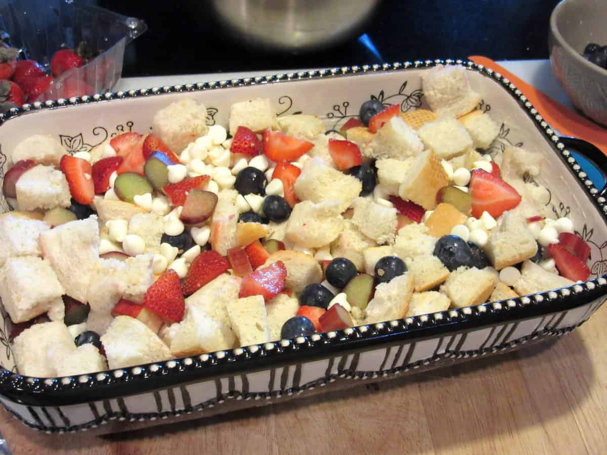 An unbaked bread pudding with berries and white chocolate.