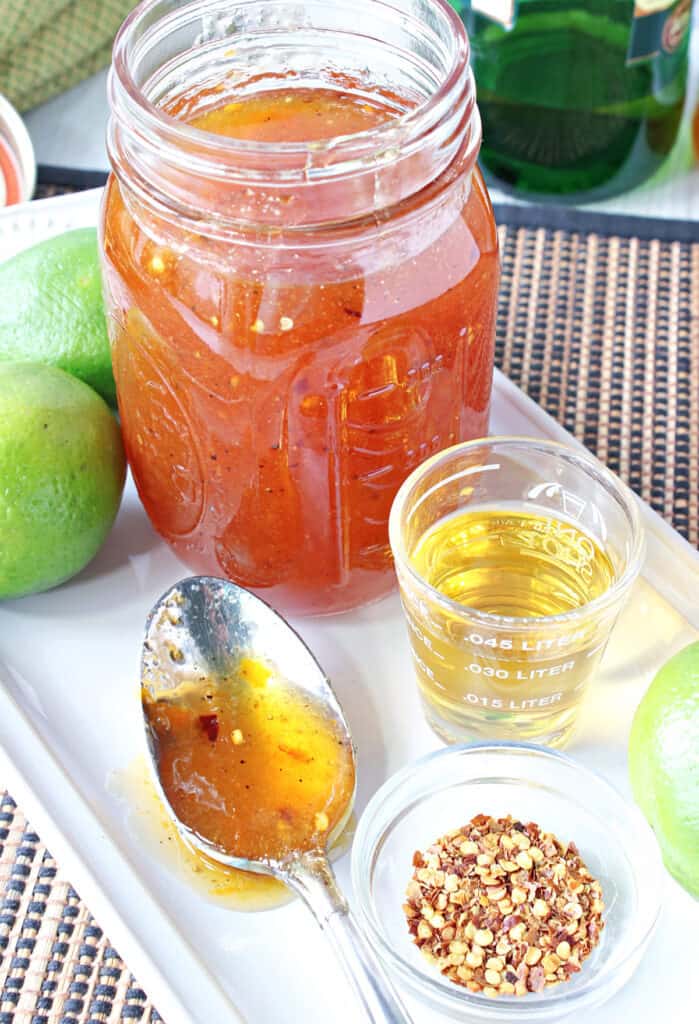 A mason jar, a spoon, and a shot glass along with Irish Whisky Glaze and some limes.