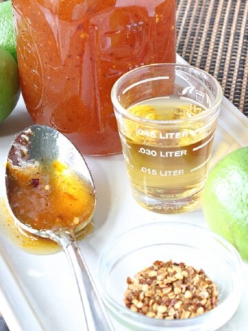 A spoon and jar with Irish Whiskey Glaze on a white platter.