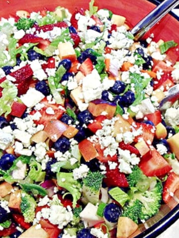 A colorful Summertime Chopped Salad with blueberries, romaine, strawberries, and blue cheese.