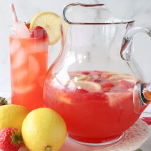 A pitcher of Pink Lemonade with Strawberry Simple Syrup and ice.