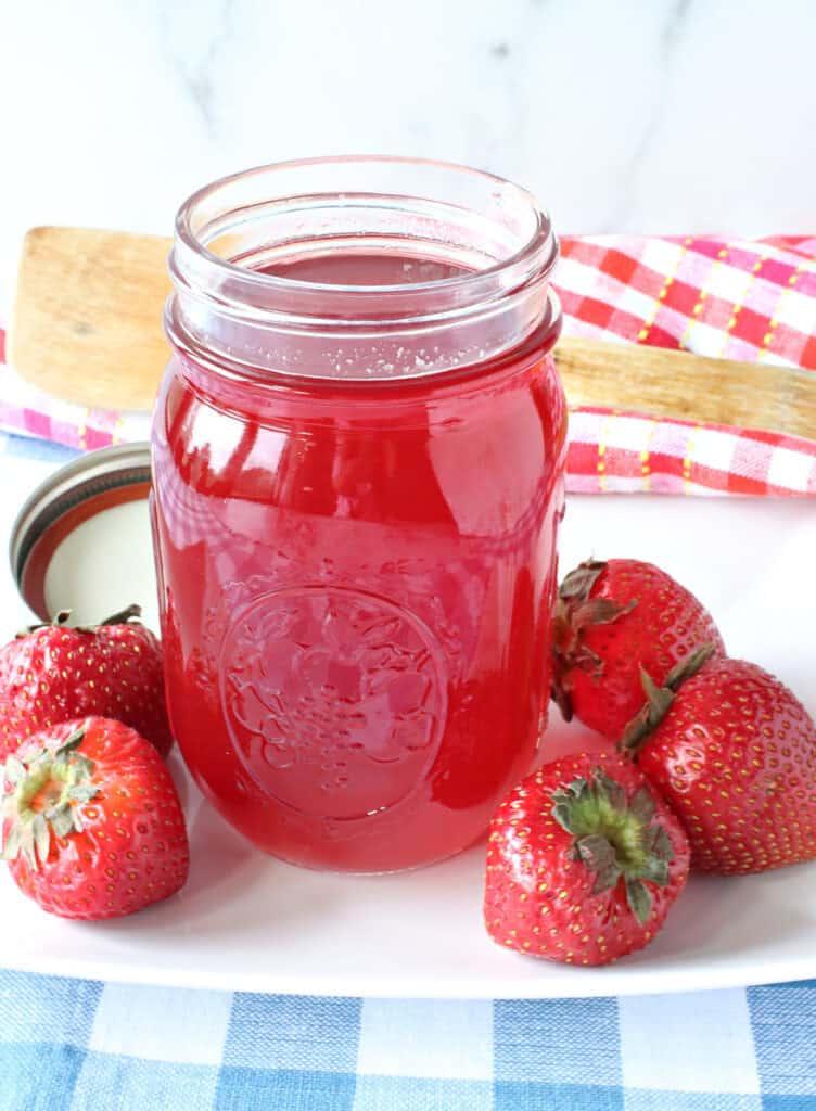 A mason jar filled with Strawberry Simple Syrup made from monk fruit sweetener.