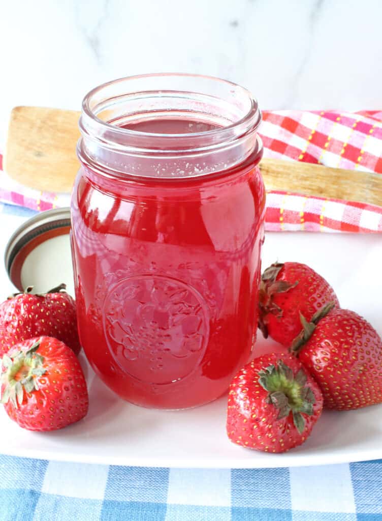 A mason jar filled with Lite Strawberry Simple Syrup made from monk fruit sweetener.