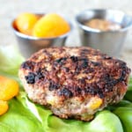 A browned Pork Burger with Dried Apricots on a lettuce leaf.
