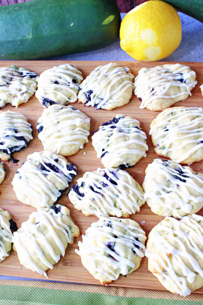 A vertical closeup of a brown wooden tray filled with Zucchini Ricotta Cookies drizzled with icing.