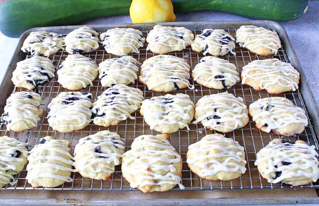 A baking sheet filled with Zucchini Ricotta Cookies that are drizzled with icing.