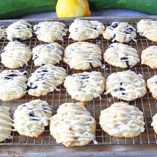 A baking sheet filled with Zucchini Ricotta Cookies that are drizzled with icing.