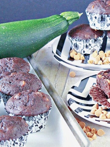 A tray of Chocolate Zucchini Muffins with Peanut Butter on the side along with a plate of muffins in the background.