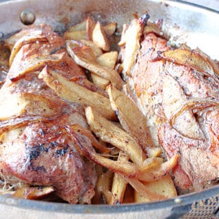 A closeup of a silver skillet filled with Skillet Pork Tenderloin with Cinnamon Apples.