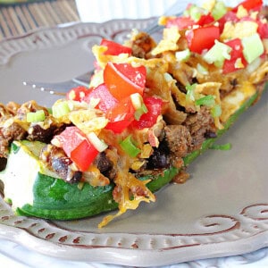 A colorful Taco-Filled Zucchini Boat on a plate.