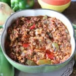 A green pepper stew with tomatoes, onions, rice and ground beef in a cute green pepper casserole dish.