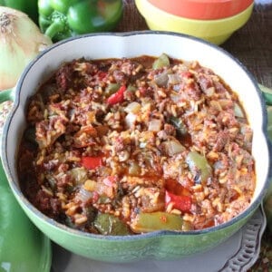 A green pepper stew with tomatoes, onions, rice and ground beef in a cute green pepper casserole dish.