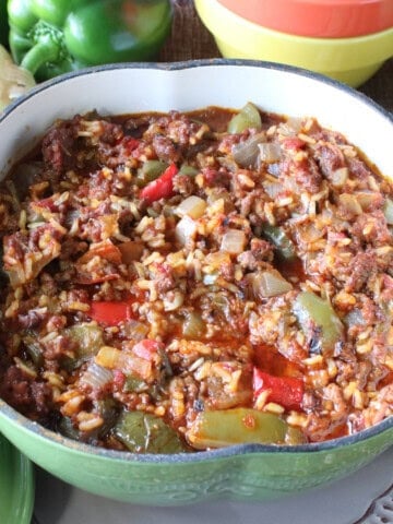 A green pepper stew with tomatoes, onions, rice and ground beef in a cute green pepper casserole dish.