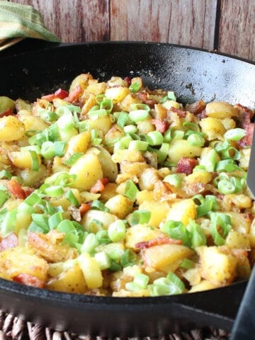 German Fried Potatoes in a cast iron skillet with a spatula.