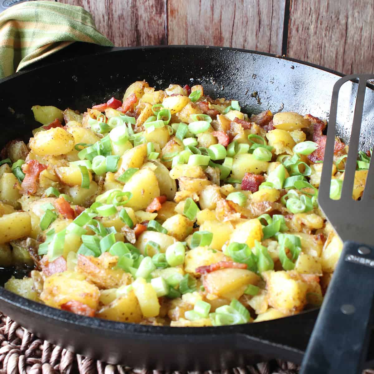 German Fried Potatoes in a cast iron skillet with a spatula.